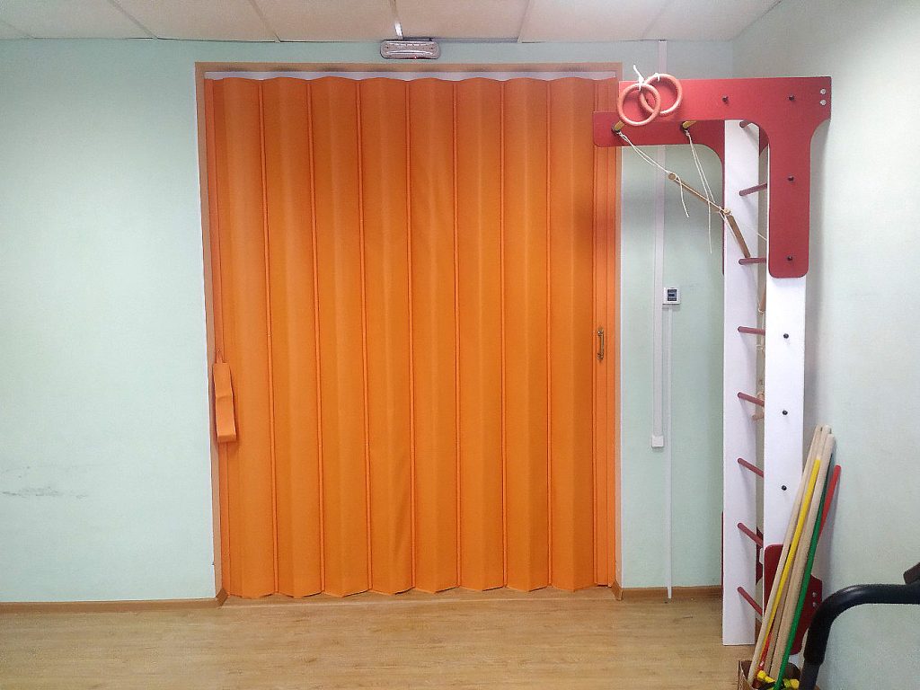 Оранжевая раздвижная мягкая перегородка для фитнес комнаты.