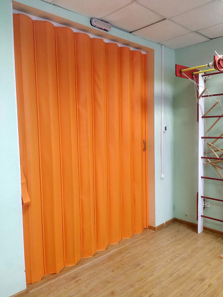 Оранжевая раздвижная мягкая перегородка для фитнес комнаты.