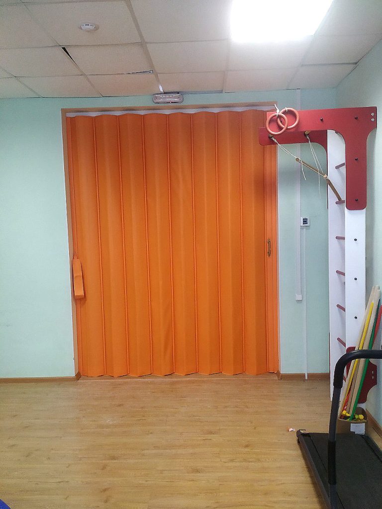 Оранжевая раздвижная мягкая перегородка для фитнес комнаты.